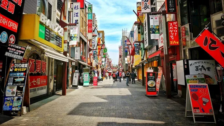 Crowded Tokyo street with colorful signs and people walking during daytime