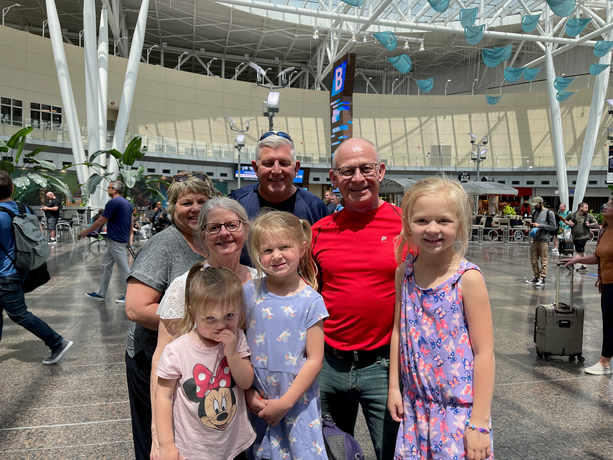 The Clarkson family with both sets of grandparents at the airport before departing for full-time travel in May 2022